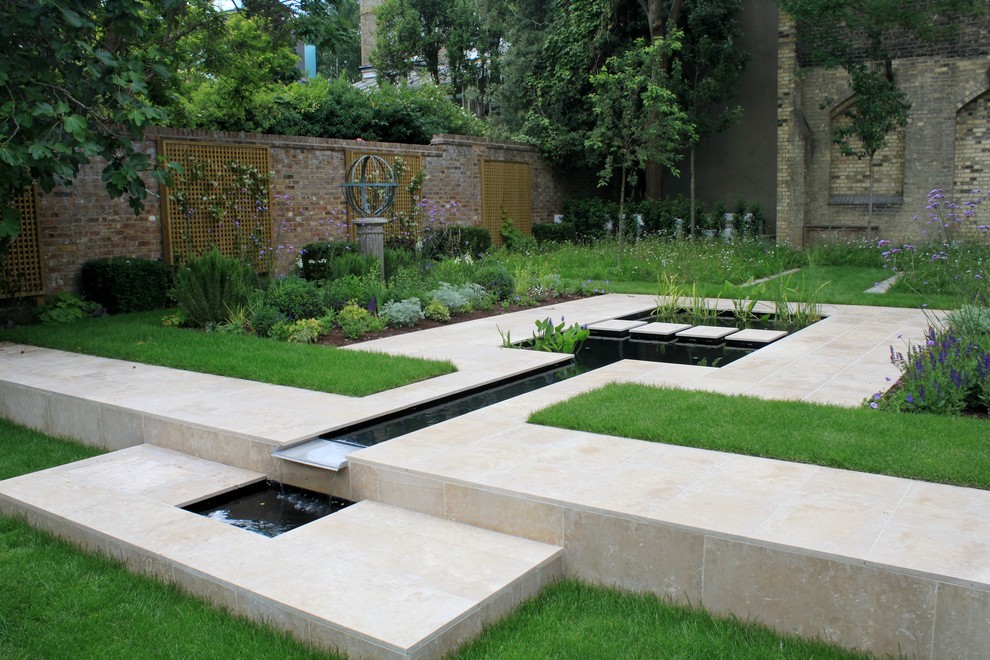 Imagen de jardín actual con fuente, exposición parcial al sol y adoquines de piedra natural
