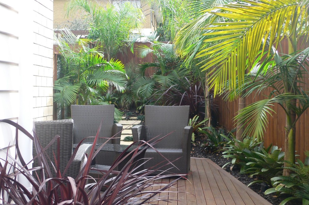 Ejemplo de jardín tropical pequeño en patio lateral con fuente, exposición parcial al sol y entablado
