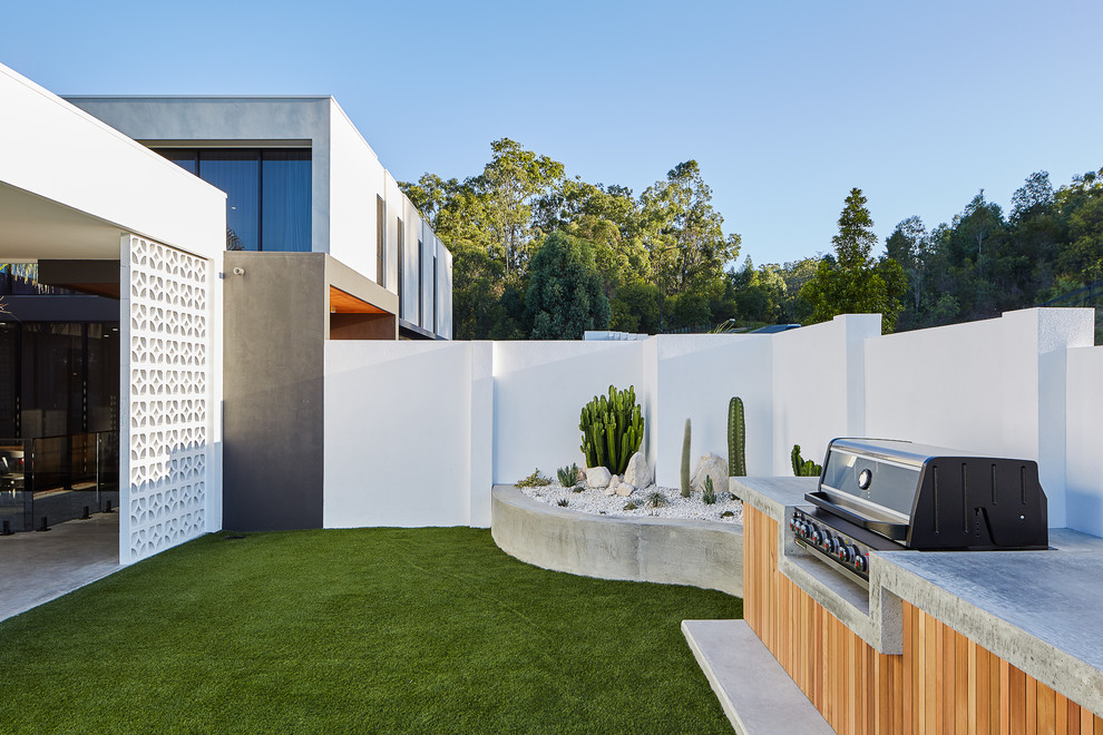Diseño de jardín moderno en patio trasero con adoquines de hormigón