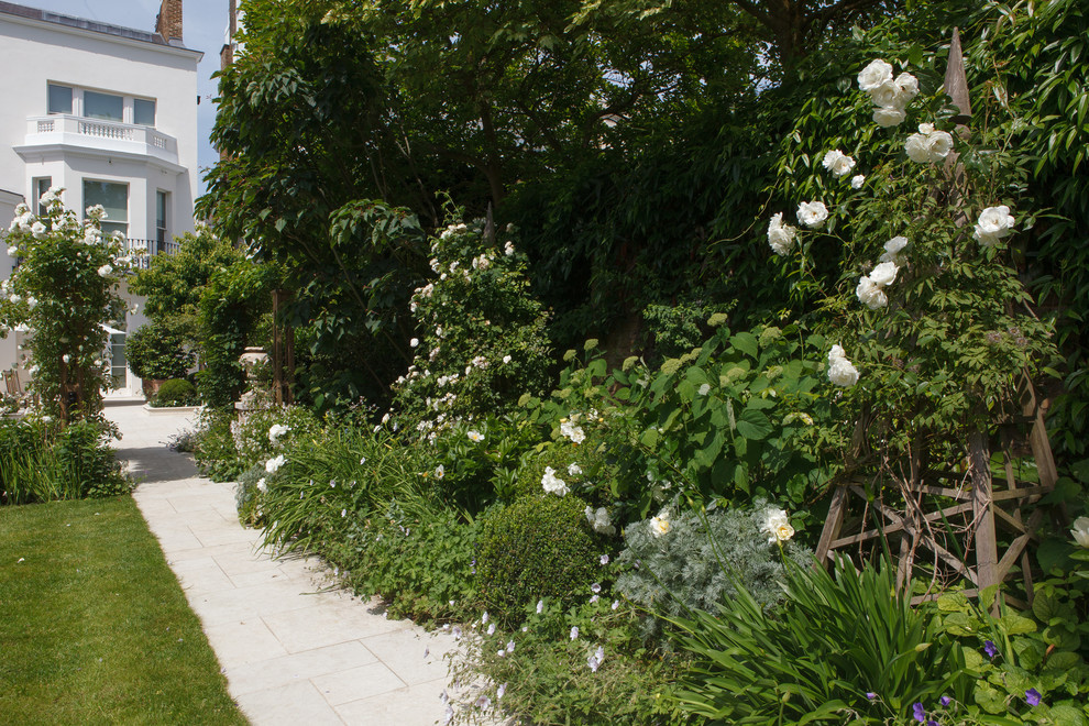 Diseño de jardín clásico de tamaño medio en verano en patio con jardín francés, exposición total al sol y adoquines de piedra natural