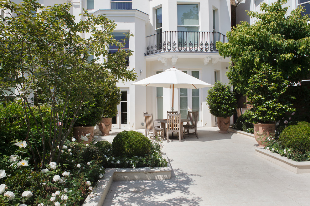 Esempio di un giardino formale tradizionale esposto in pieno sole di medie dimensioni e in cortile in estate con pavimentazioni in pietra naturale