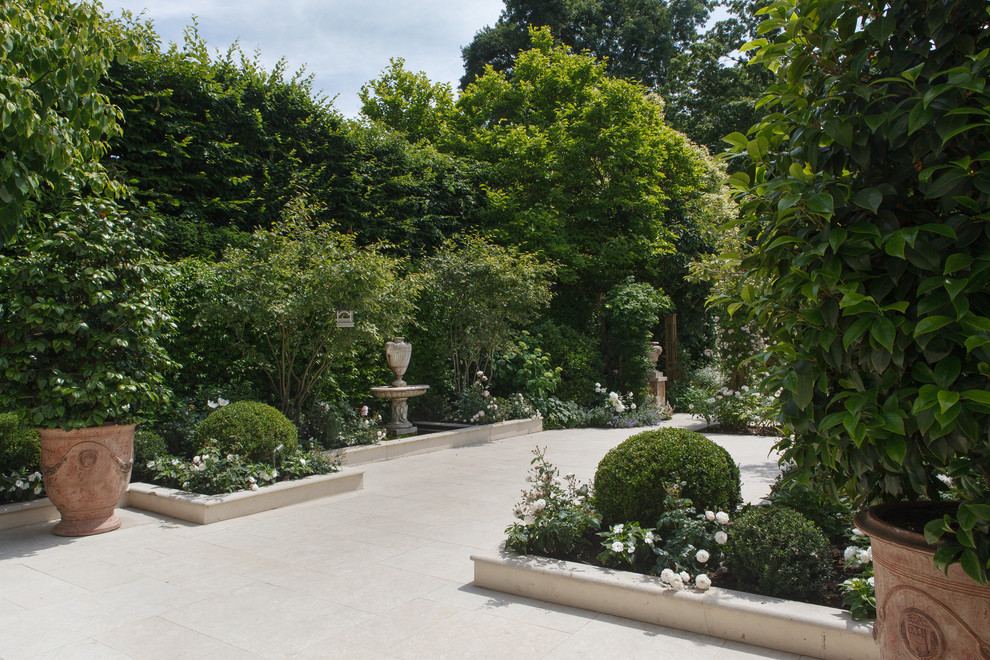 Photo of a medium sized classic courtyard formal full sun garden for summer in London with natural stone paving.