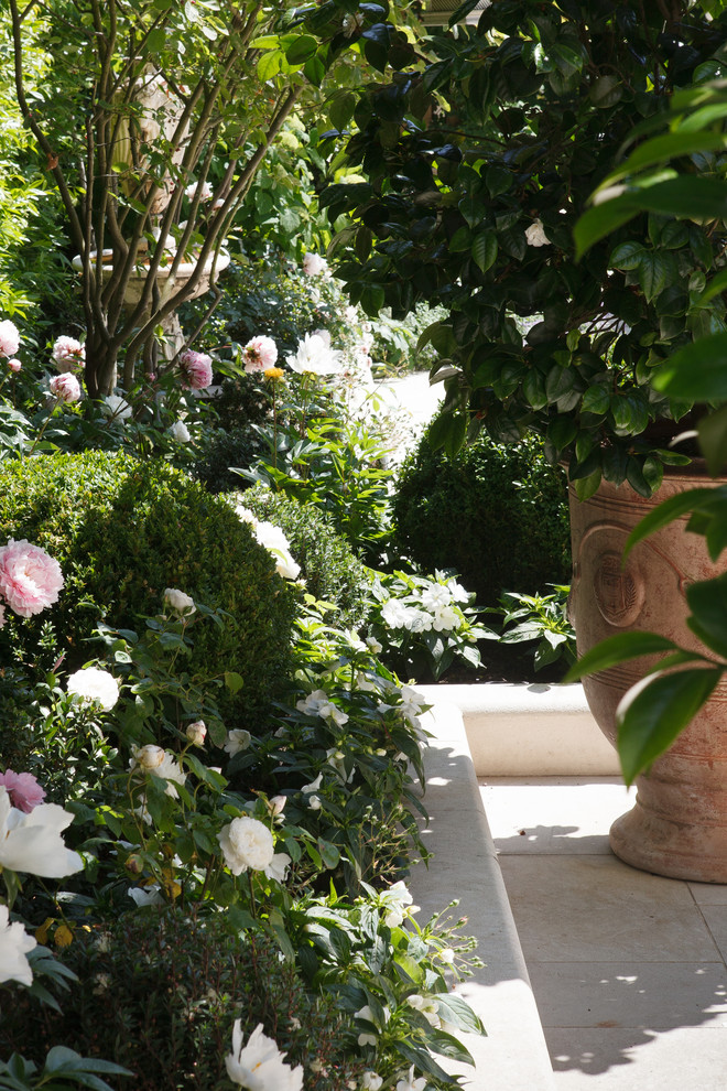 Ispirazione per un giardino formale tradizionale esposto in pieno sole di medie dimensioni e in cortile in estate con un muro di contenimento e pavimentazioni in pietra naturale