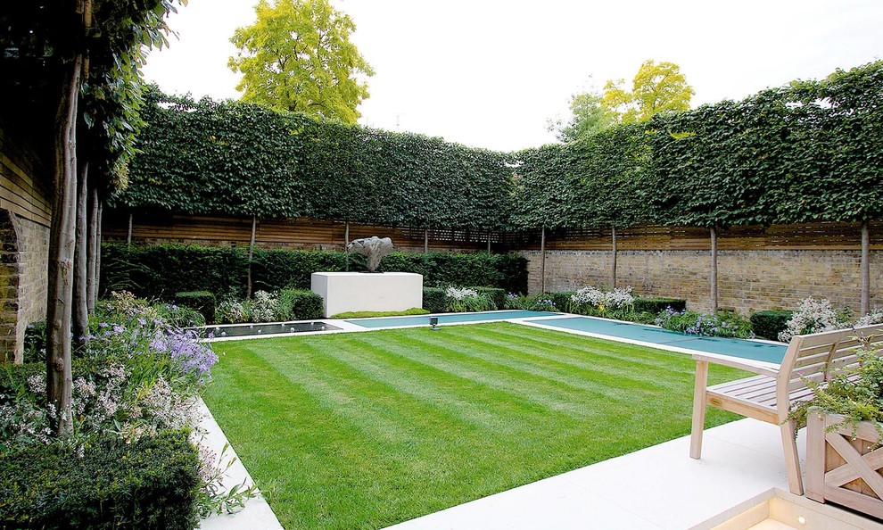 Diseño de camino de jardín clásico en patio trasero con jardín francés, exposición total al sol y adoquines de piedra natural