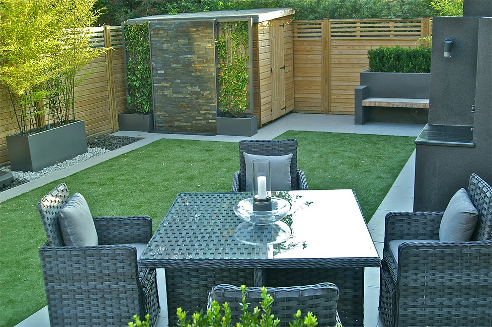 Immagine di un giardino formale minimal esposto in pieno sole di medie dimensioni e dietro casa in estate con fontane e pavimentazioni in cemento