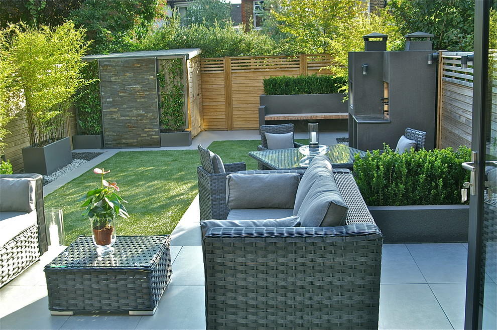 Photo of a mid-sized contemporary full sun backyard concrete paver landscaping in London for summer.