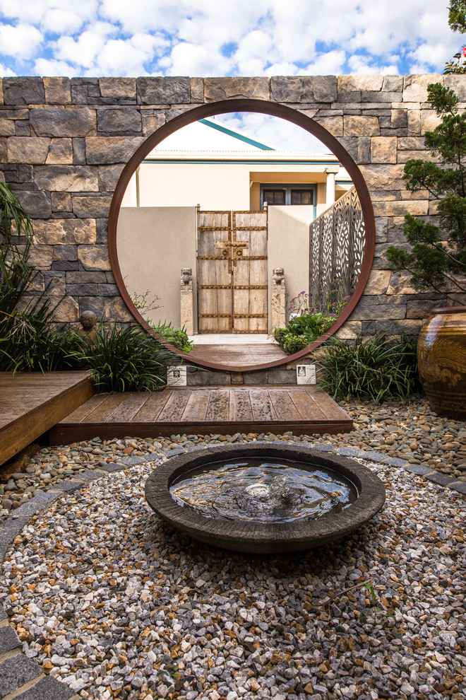 Inspiration for a large full sun courtyard water fountain landscape in Sydney with decking.