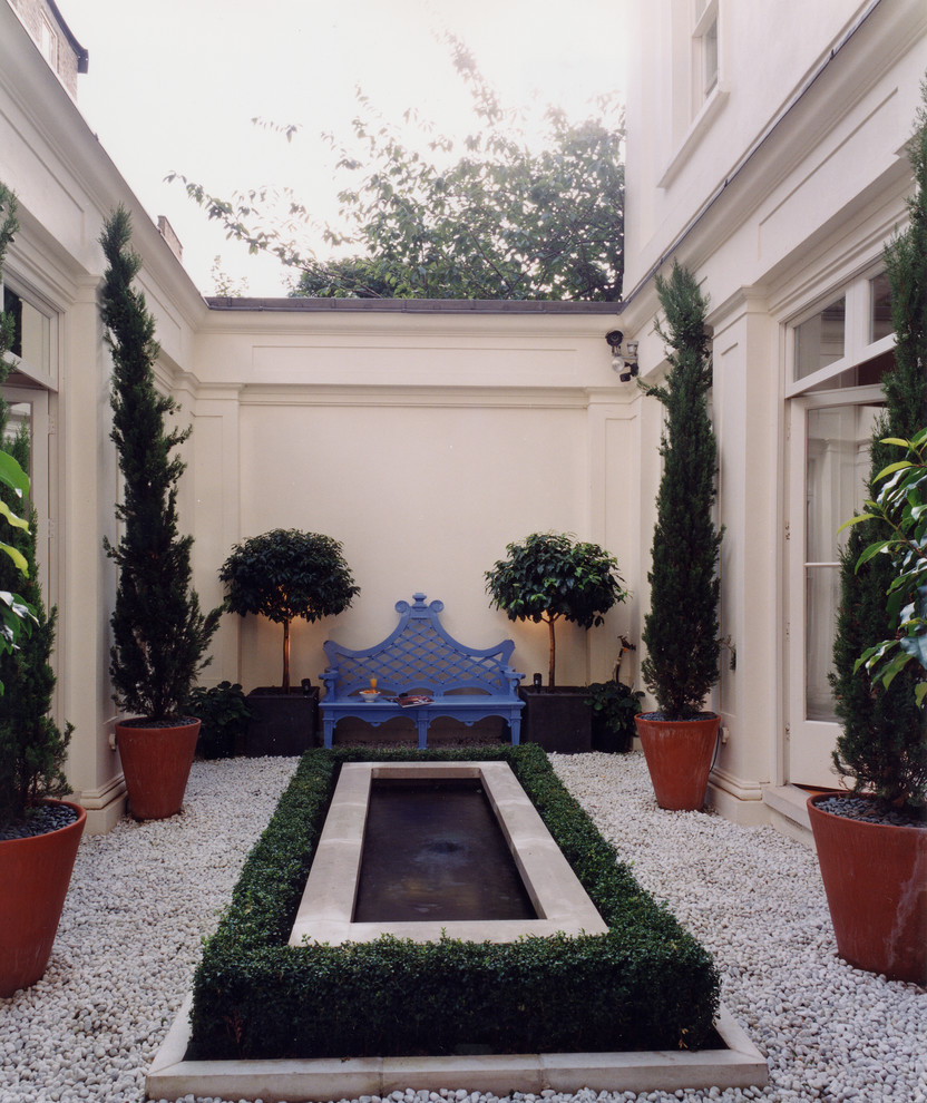 Traditional side garden in London with a water feature.