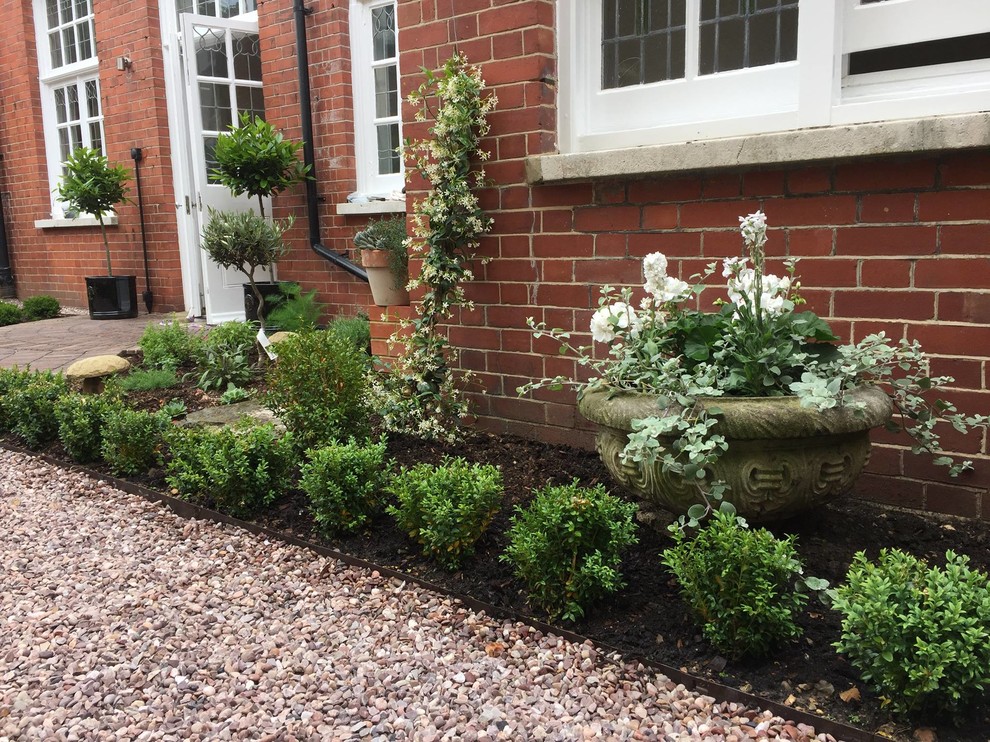 Photo of a medium sized classic courtyard formal partial sun garden for summer in Sussex with a potted garden and gravel.