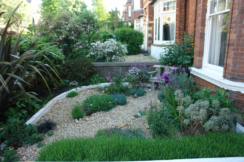 Small nautical front xeriscape partial sun garden in Sussex with gravel.