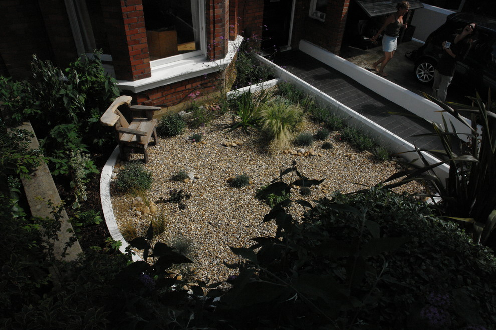 This is an example of a small nautical front xeriscape partial sun garden in Sussex with gravel.