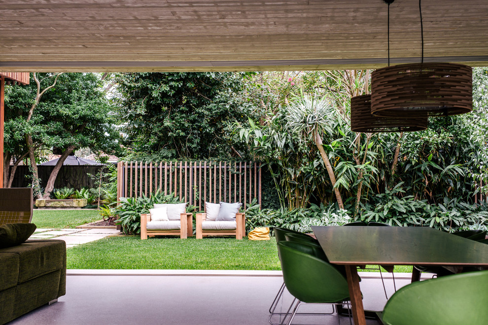 Foto di un grande giardino minimalista esposto in pieno sole davanti casa in autunno con un muro di contenimento