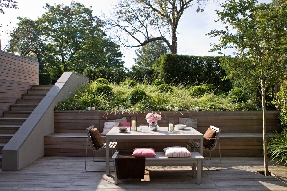 Modelo de jardín minimalista de tamaño medio en patio trasero con entablado y jardín francés