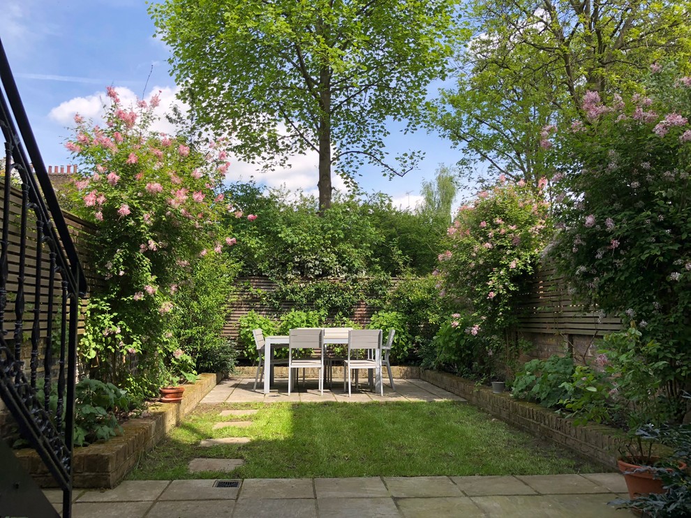 Classic back garden in London with concrete paving.
