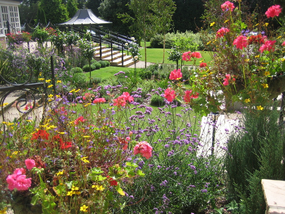 Diseño de camino de jardín tradicional grande en patio trasero con jardín francés y gravilla
