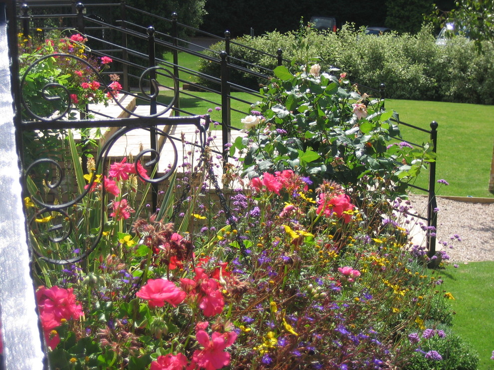 Imagen de camino de jardín tradicional grande en patio trasero con jardín francés y gravilla