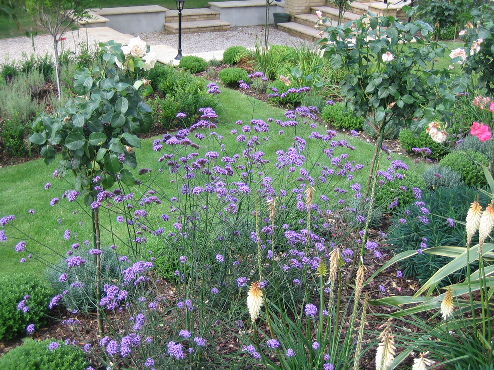 Cette image montre un grand jardin arrière traditionnel avec du gravier.