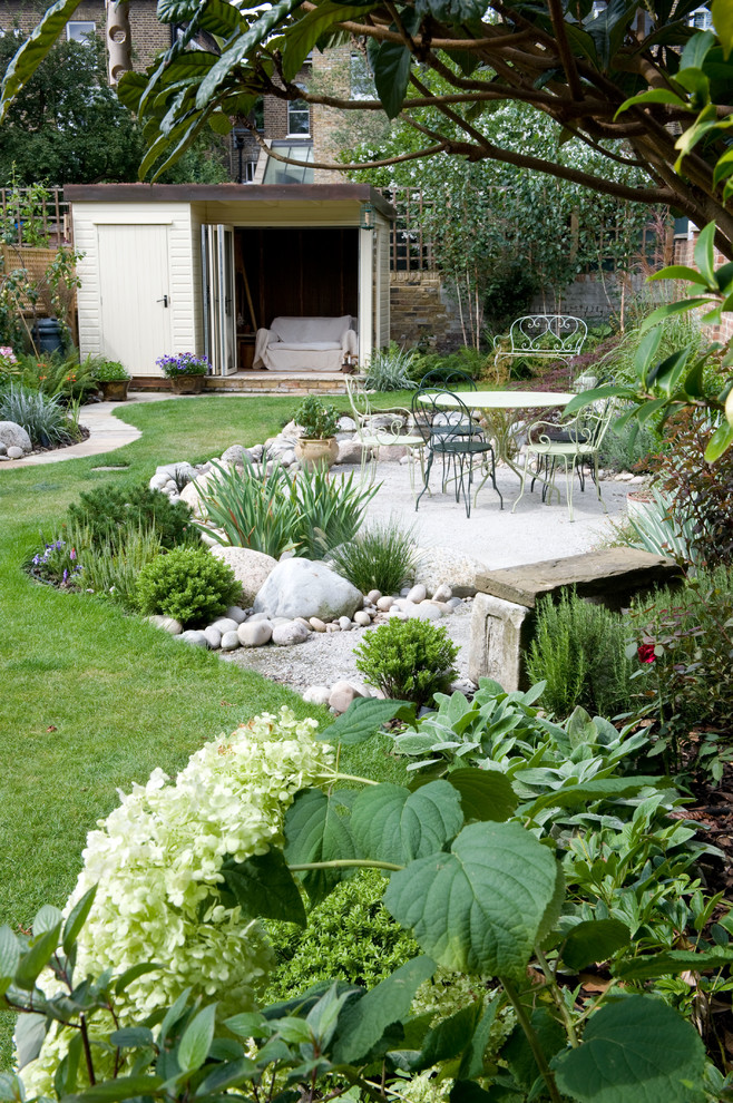 На фото: летний регулярный сад среднего размера на заднем дворе в классическом стиле с полуденной тенью и покрытием из каменной брусчатки