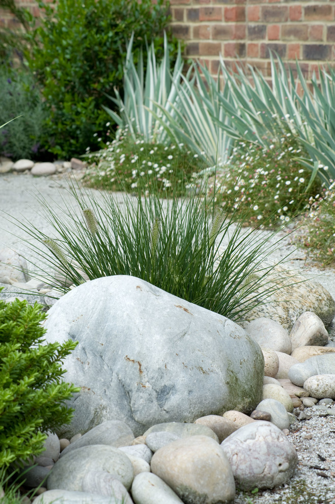 Foto de jardín clásico de tamaño medio en verano en patio trasero con jardín francés, exposición parcial al sol y adoquines de piedra natural
