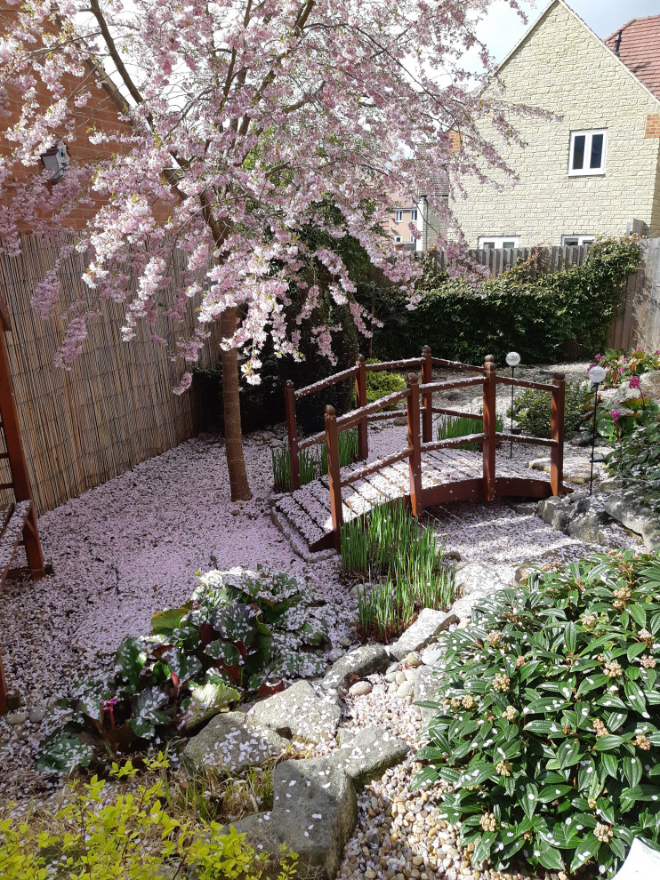 Mittelgroßer Asiatischer Garten hinter dem Haus mit Steindeko, direkter Sonneneinstrahlung und Flusssteinen in Oxfordshire