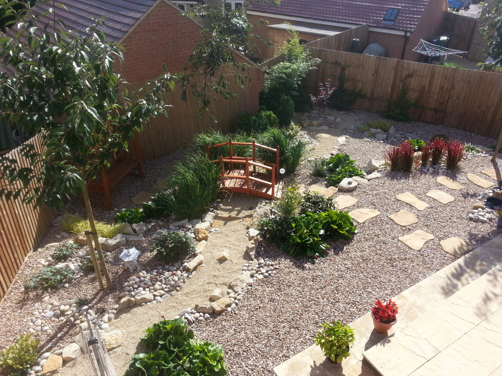 Medium sized world-inspired back full sun garden in Oxfordshire with a rockery and decorative stones.