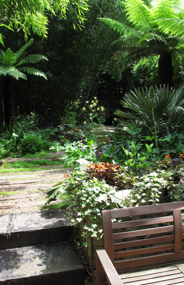 ロンドンにあるお手頃価格の小さな、夏のトロピカルスタイルのおしゃれな裏庭 (日陰、天然石敷き) の写真