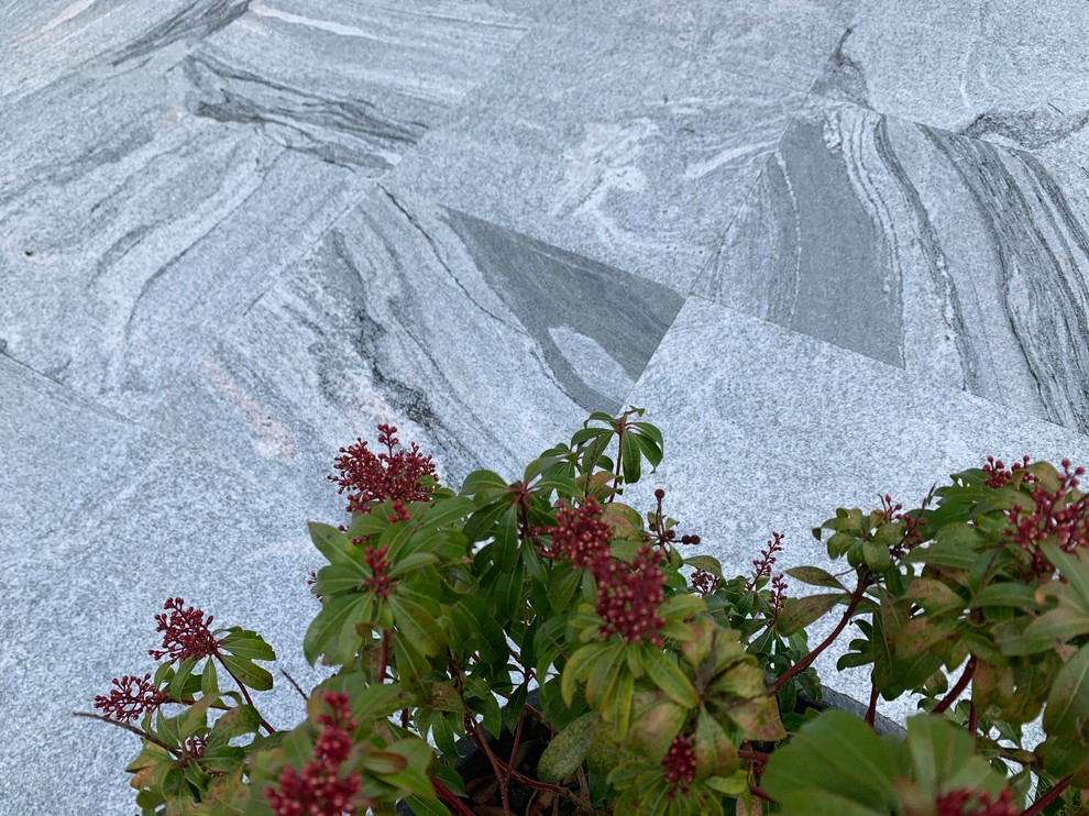 Immagine di un giardino eclettico con pavimentazioni in pietra naturale