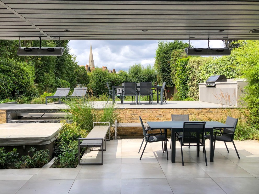 Geometrischer, Mittelgroßer, Halbschattiger Moderner Gartenkamin im Sommer, hinter dem Haus mit Natursteinplatten in London
