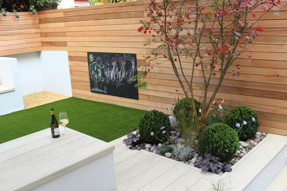 Photo of a small contemporary back partial sun garden in London with decking.