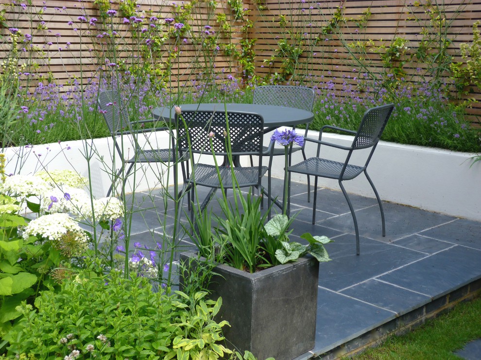Mittelgroßer Moderner Garten hinter dem Haus mit Natursteinplatten in London