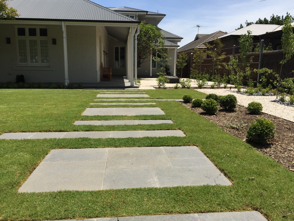 This is an example of a mid-sized traditional full sun front yard stone formal garden in Adelaide for summer.