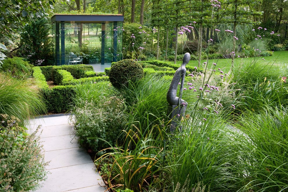 Großer Moderner Garten hinter dem Haus mit Spielgerät, direkter Sonneneinstrahlung und Natursteinplatten in London