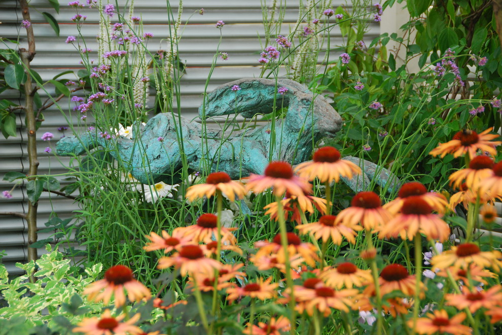 Kleiner, Halbschattiger Nordischer Garten im Frühling, hinter dem Haus mit Kübelpflanzen und Pflastersteinen in London