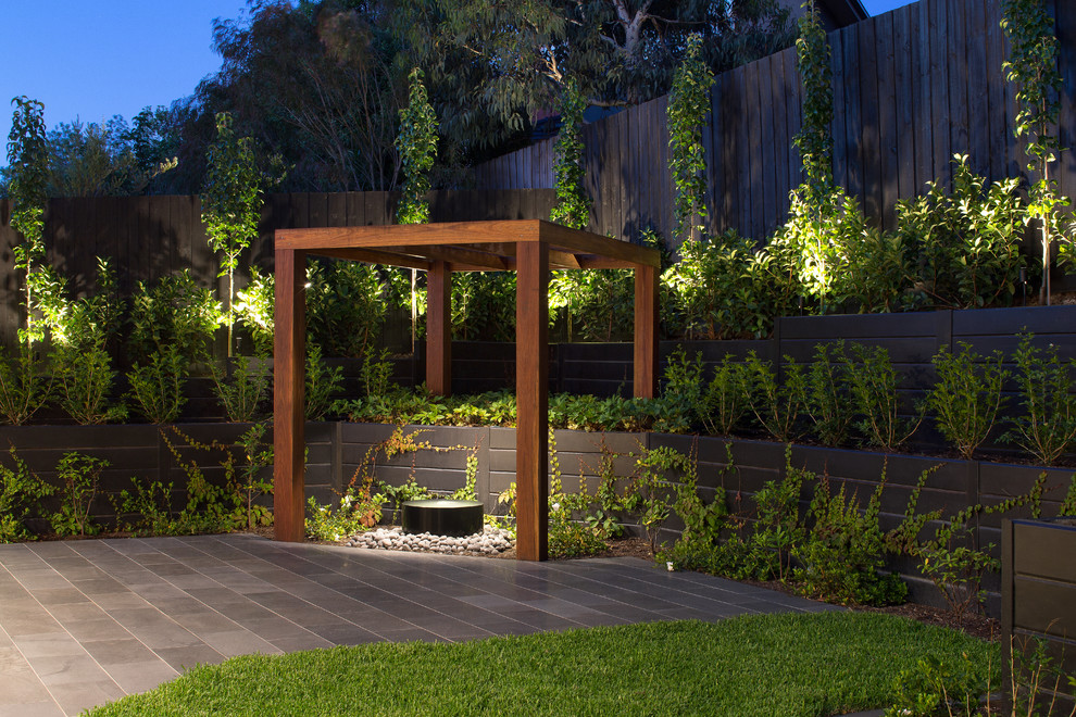 Idéer för en mellanstor modern trädgård i delvis sol på våren, med en stödmur och naturstensplattor