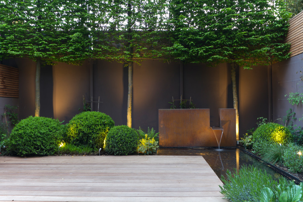 Contemporary garden in Berkshire with a water feature and decking.