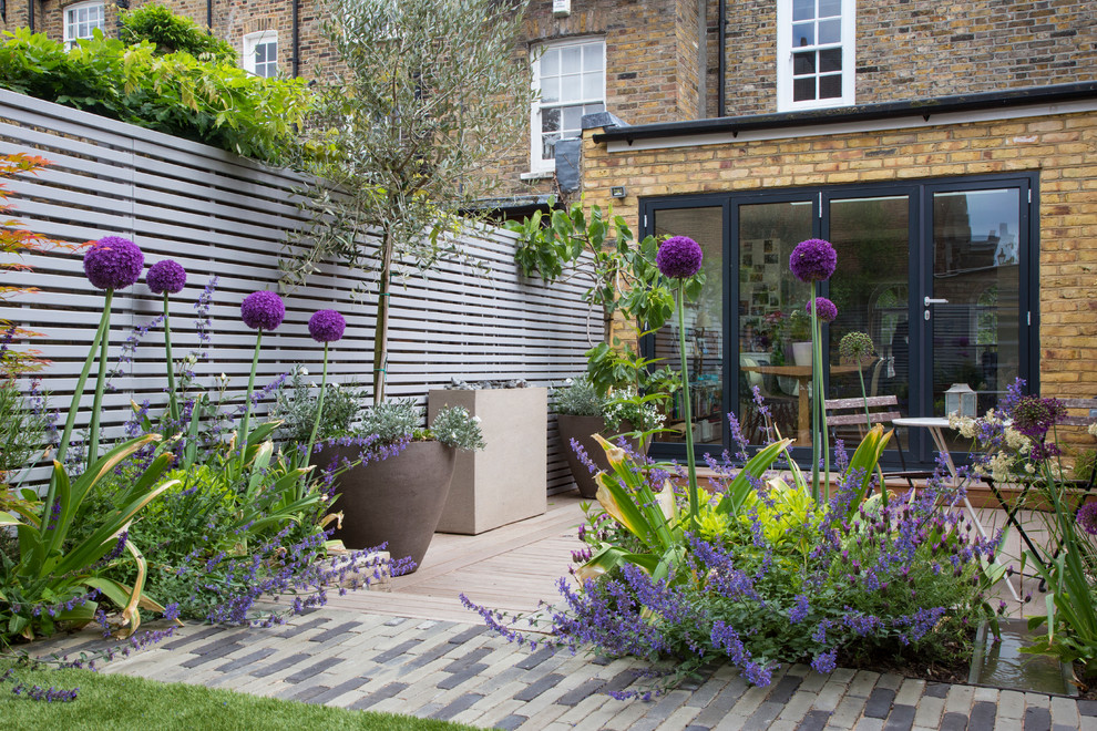 Свежая идея для дизайна: маленький солнечный, летний регулярный сад на заднем дворе в современном стиле с хорошей освещенностью и настилом для на участке и в саду - отличное фото интерьера