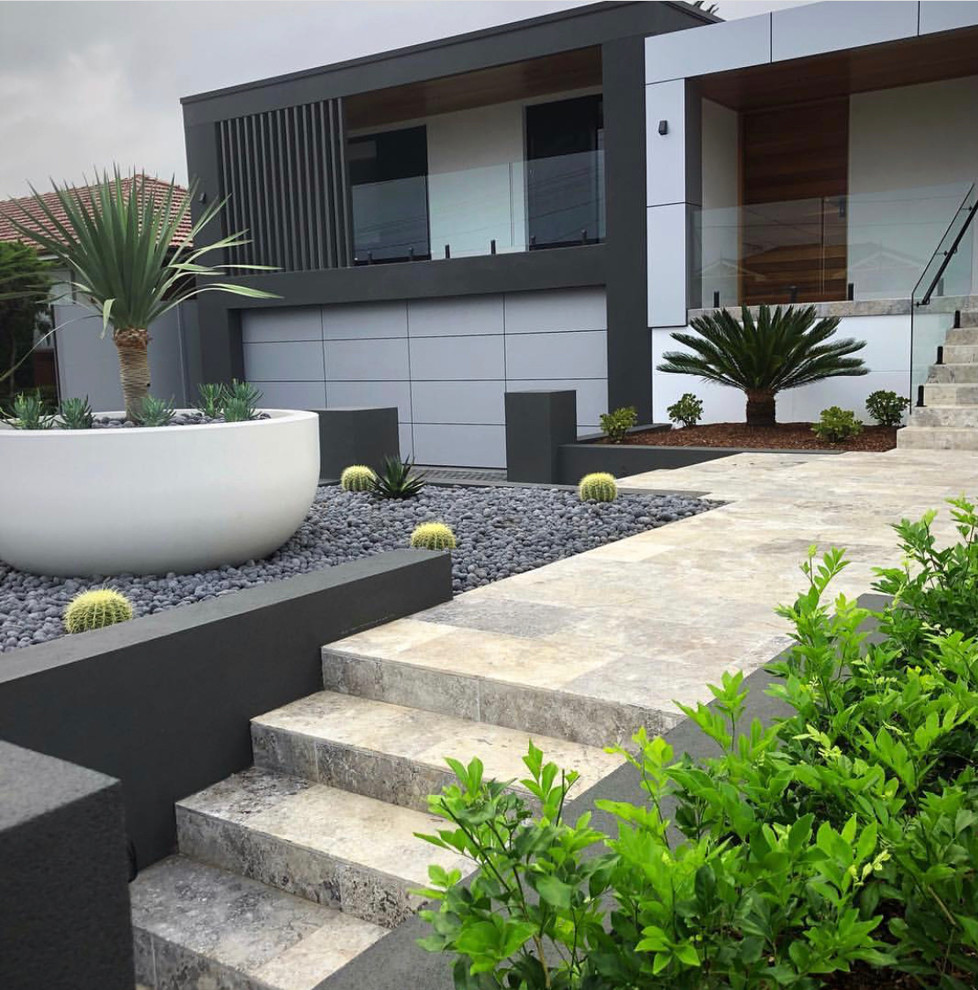 Immagine di un grande giardino xeriscape moderno esposto in pieno sole davanti casa con un ingresso o sentiero e pavimentazioni in pietra naturale