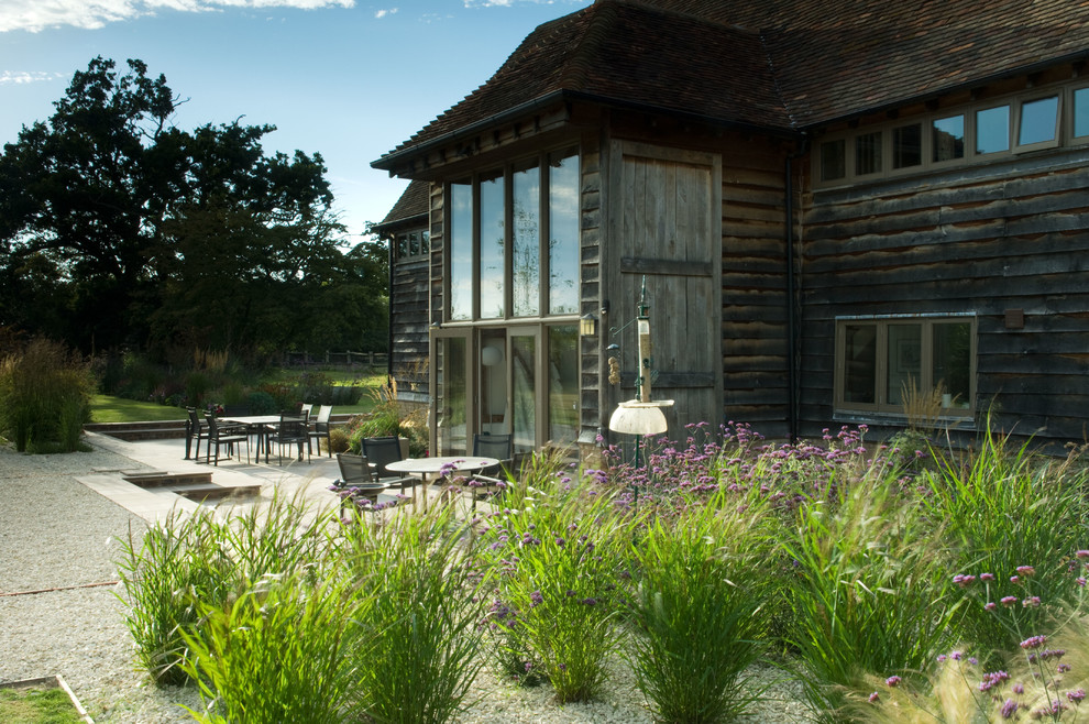 Idee per un ampio giardino country dietro casa in estate con ghiaia