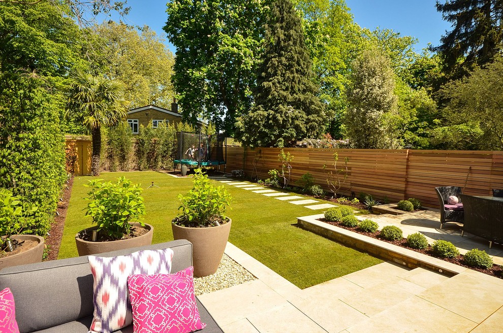 Ejemplo de jardín actual grande en verano en patio trasero con exposición parcial al sol, adoquines de piedra natural y jardín de macetas