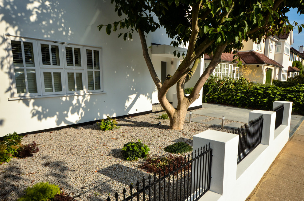 Design ideas for a small contemporary full sun front yard gravel landscaping in London for summer.