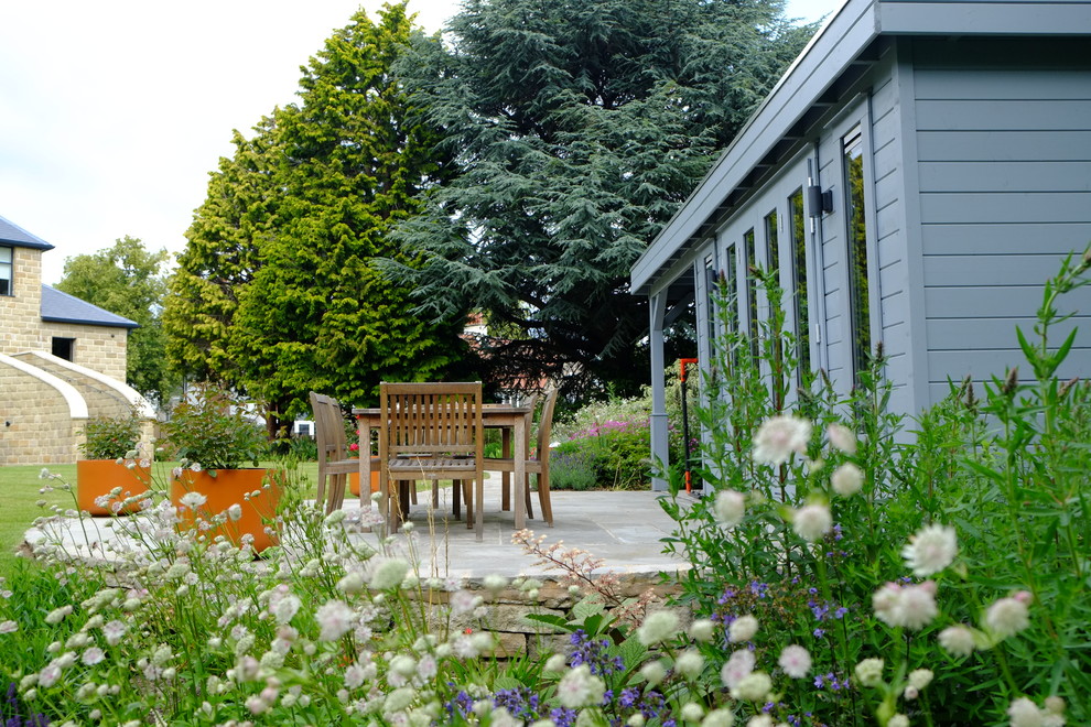 Cette photo montre un grand jardin arrière moderne l'été avec une exposition ensoleillée et des pavés en pierre naturelle.