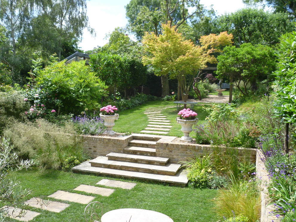 Exemple d'un aménagement d'entrée ou allée de jardin arrière chic avec une exposition partiellement ombragée et des pavés en pierre naturelle.