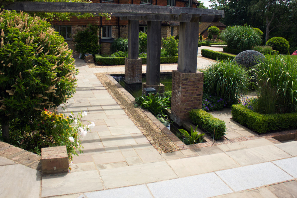 Immagine di un ampio giardino stile shabby esposto in pieno sole dietro casa in estate con un ingresso o sentiero e pavimentazioni in pietra naturale