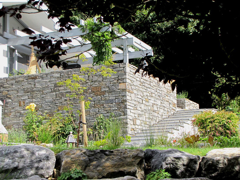 Идея дизайна: большой солнечный участок и сад на склоне в стиле кантри с хорошей освещенностью и покрытием из каменной брусчатки
