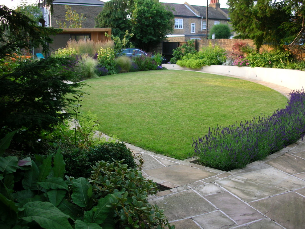 This is an example of a contemporary garden for summer in London with natural stone paving.