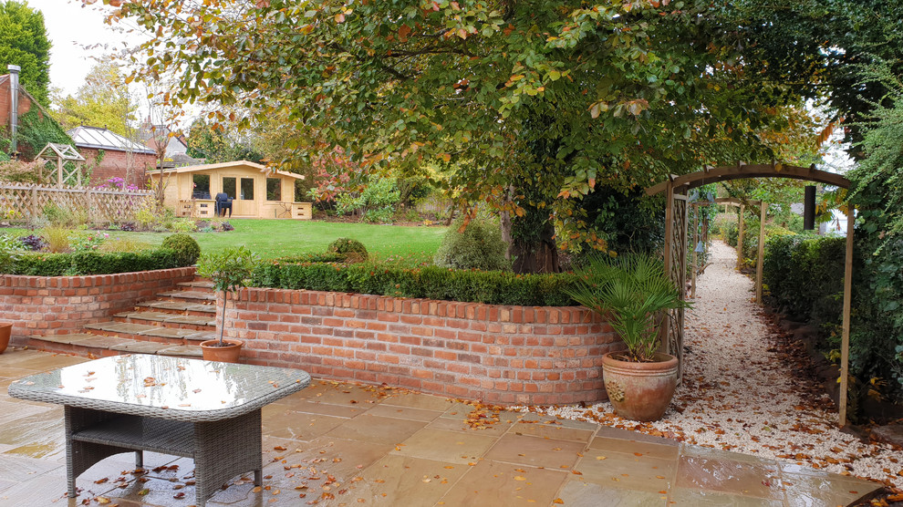 Design ideas for a large traditional back garden in West Midlands with brick paving.
