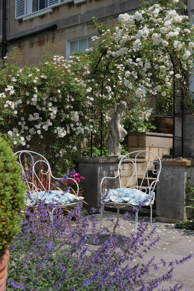 Exemple d'un jardin avec pergola romantique.