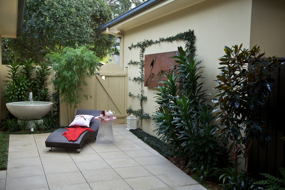 This is an example of a small world-inspired courtyard fully shaded garden in Sydney with an outdoor sport court and natural stone paving.