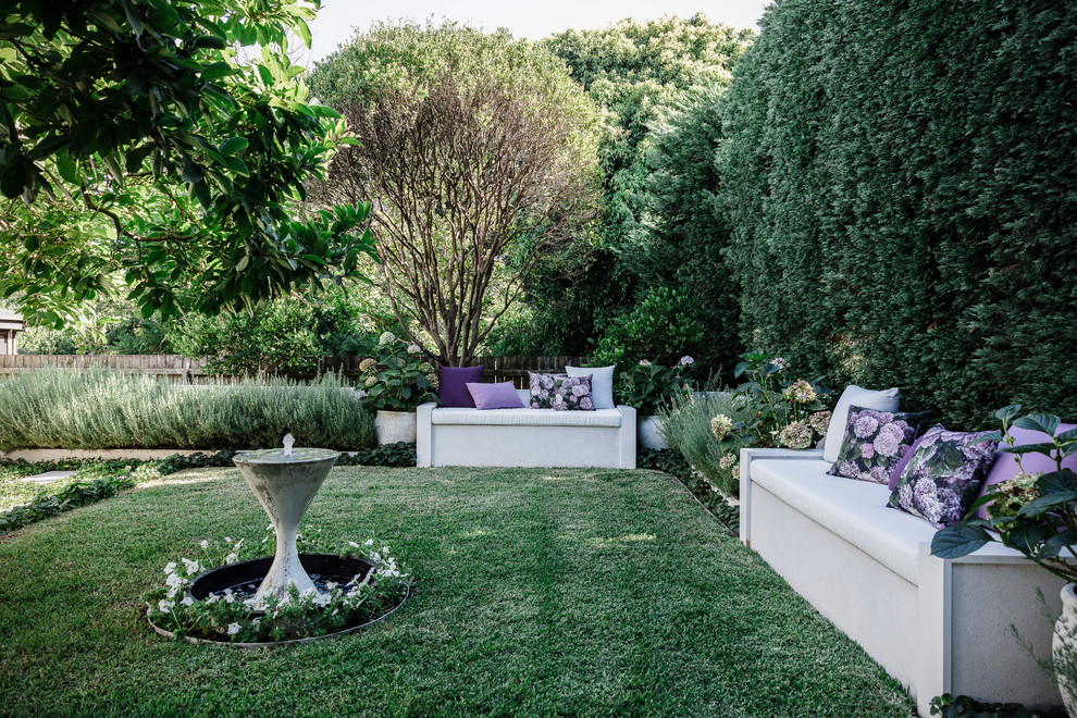 Imagen de jardín clásico renovado en patio trasero con jardín francés y fuente
