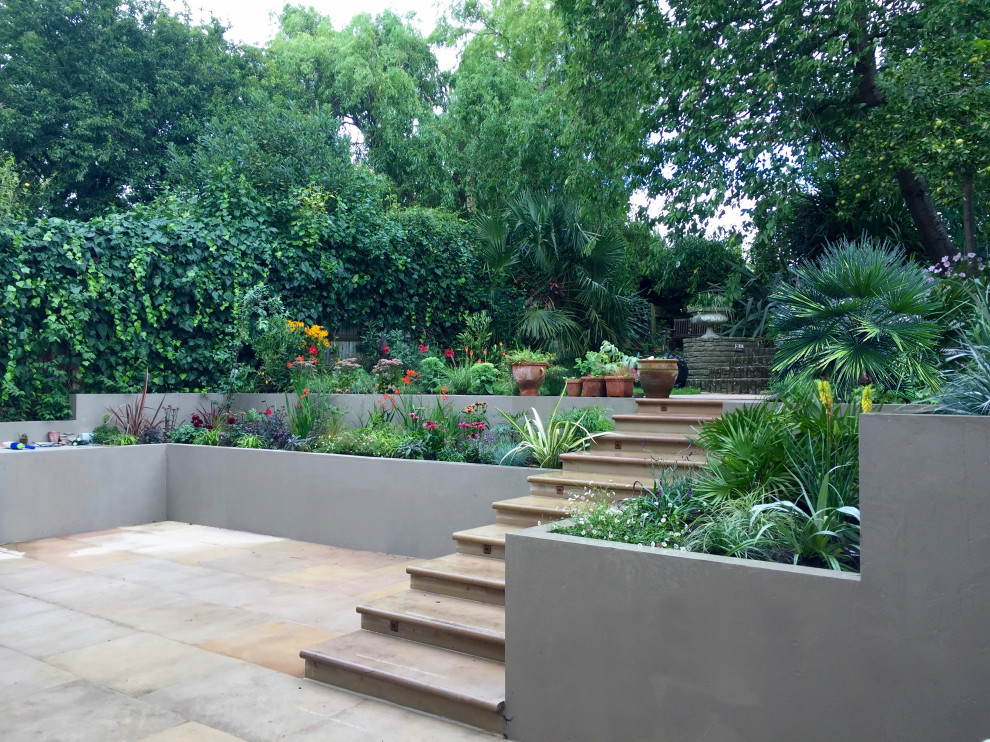 Exemple d'un jardin surélevé arrière tendance de taille moyenne et l'été avec une exposition ensoleillée et des pavés en pierre naturelle.